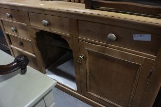 A waxed pine dresser base, fitted three drawers, "dog kennel" and two cupboards, on block base,