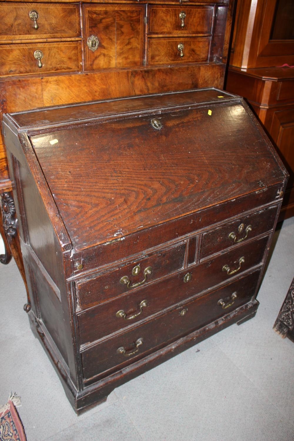 An early 18th century fall front bureau with fitted interior cupboard and well over two short and