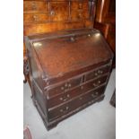 An early 18th century fall front bureau with fitted interior cupboard and well over two short and