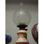 A late 19th century porcelain oil lamp with figure decorated panel, etched shade and chimney, 19"