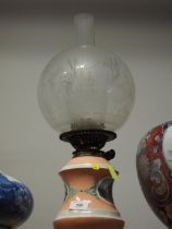 A late 19th century porcelain oil lamp with figure decorated panel, etched shade and chimney, 19"