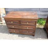 An 18th century oak panelled front chest fitted two short and two long drawers with brass knob