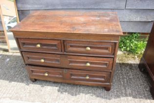 An 18th century oak panelled front chest fitted two short and two long drawers with brass knob