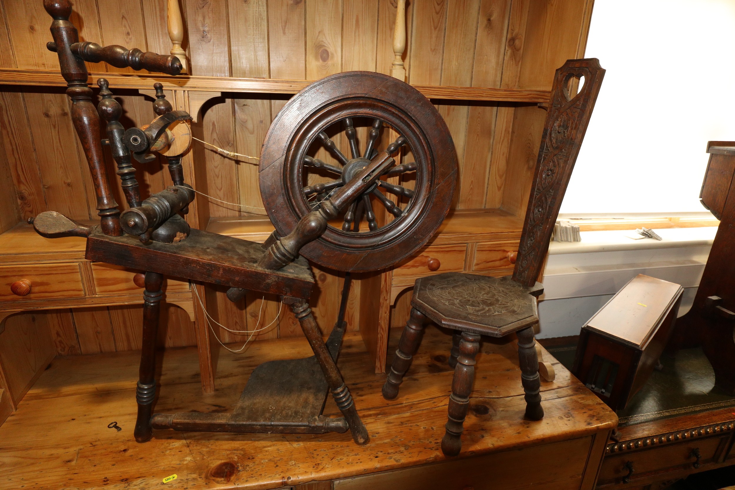 An oak and ash upright spinning wheel, 33" high, and a chip carved oak spinning stool with octagonal