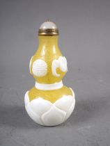 A yellow Peking glass snuff bottle with lotus design, 3" high