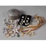 An Indian white metal circular box and cover, and a small collection of costume jewellery rings,