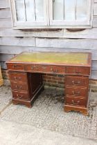 An oak double pedestal desk with green tooled lined top, fitted nine drawers, on bracket feet, 48"