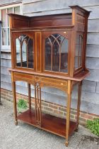 An Edwardian walnut and satinwood banded display cabinet with raised back over two Gothic lattice