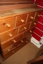 A waxed pine nest of fourteen drawers with knob handles, on block base, 41" wide x 18 1/2" deep x 43