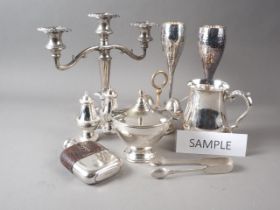 A pair of silver plated champagne flutes with hammered design, two plated mugs, a candelabra, a