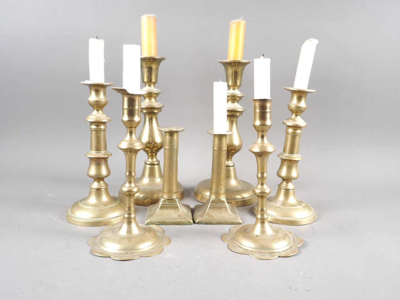 A pair of 18th century brass petal base candlesticks, and three other pairs of brass candlesticks