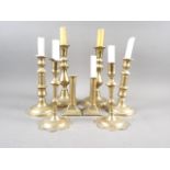 A pair of 18th century brass petal base candlesticks, and three other pairs of brass candlesticks
