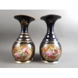 A pair of early 19th century bone china vases with flared rims and floral reserve panels on a blue