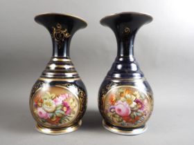 A pair of early 19th century bone china vases with flared rims and floral reserve panels on a blue