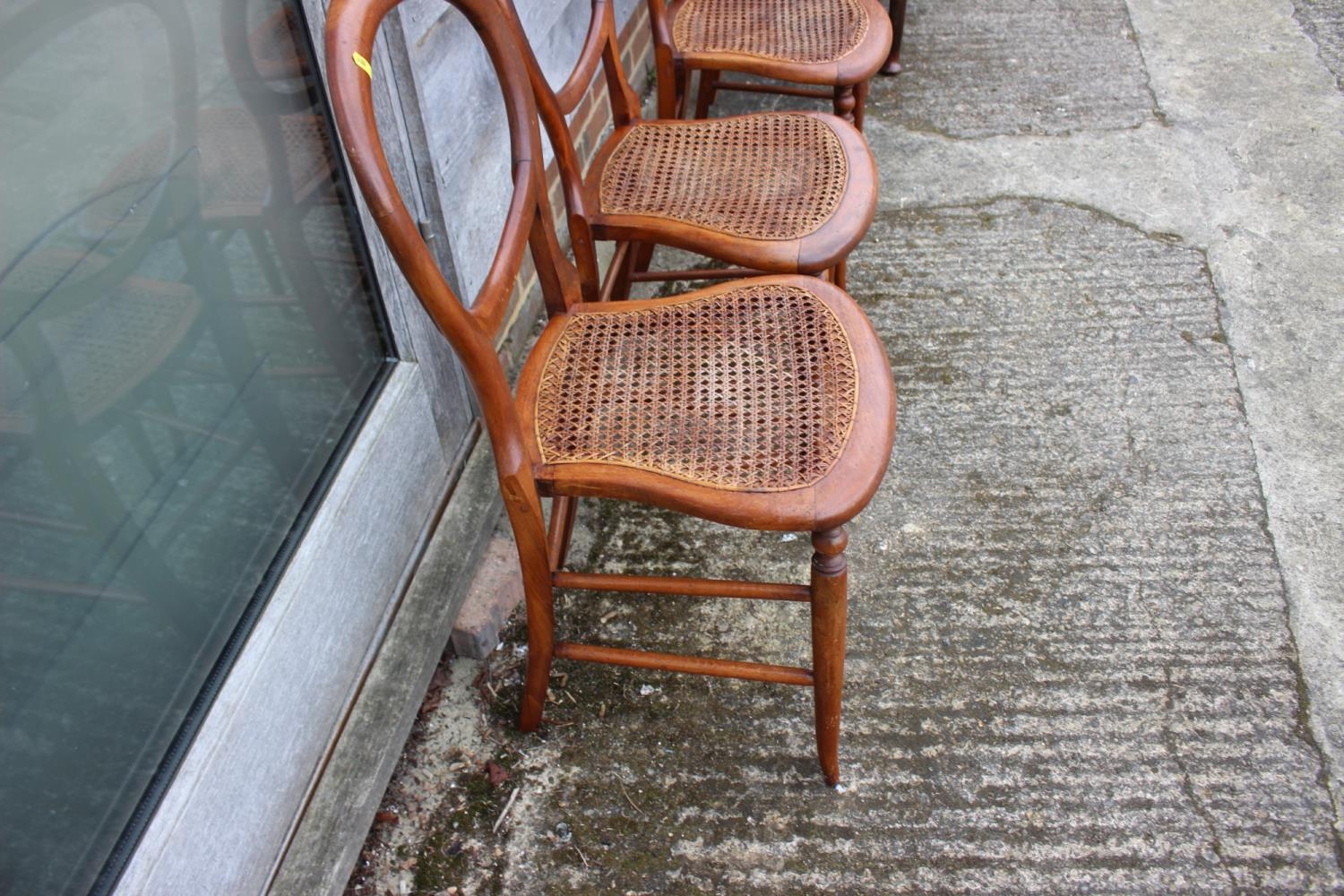 A set of four polished as walnut cane seat bedroom chairs, on turned splay supports - Image 3 of 3