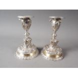 A pair of Elkington silver plated candlesticks with relief and embossed classical decoration, on