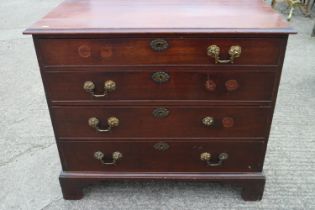 A George III mahogany chest of four long graduated drawers with gilt brass bail handles, on