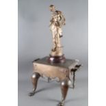 A 19th century bronze footman with two-handles, on cabriole supports, 20" wide, and a gilt spelter