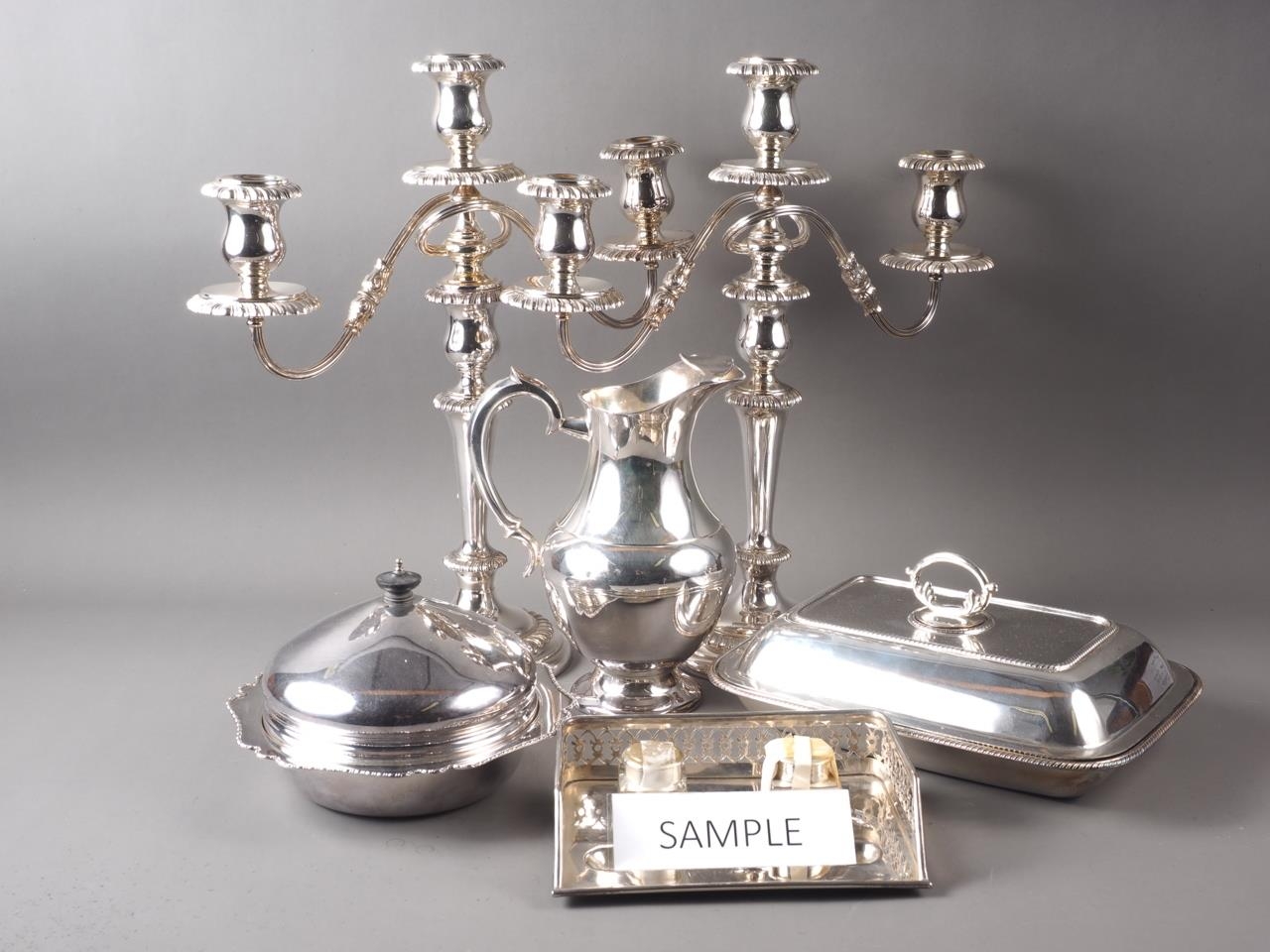 A pair of silver plated three-light table candelabra, a pair of single light candlesticks, a