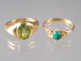 An 18ct gold and peridot single stone ring, size I, 6.9g, and a yellow metal and jade cabochon ring,