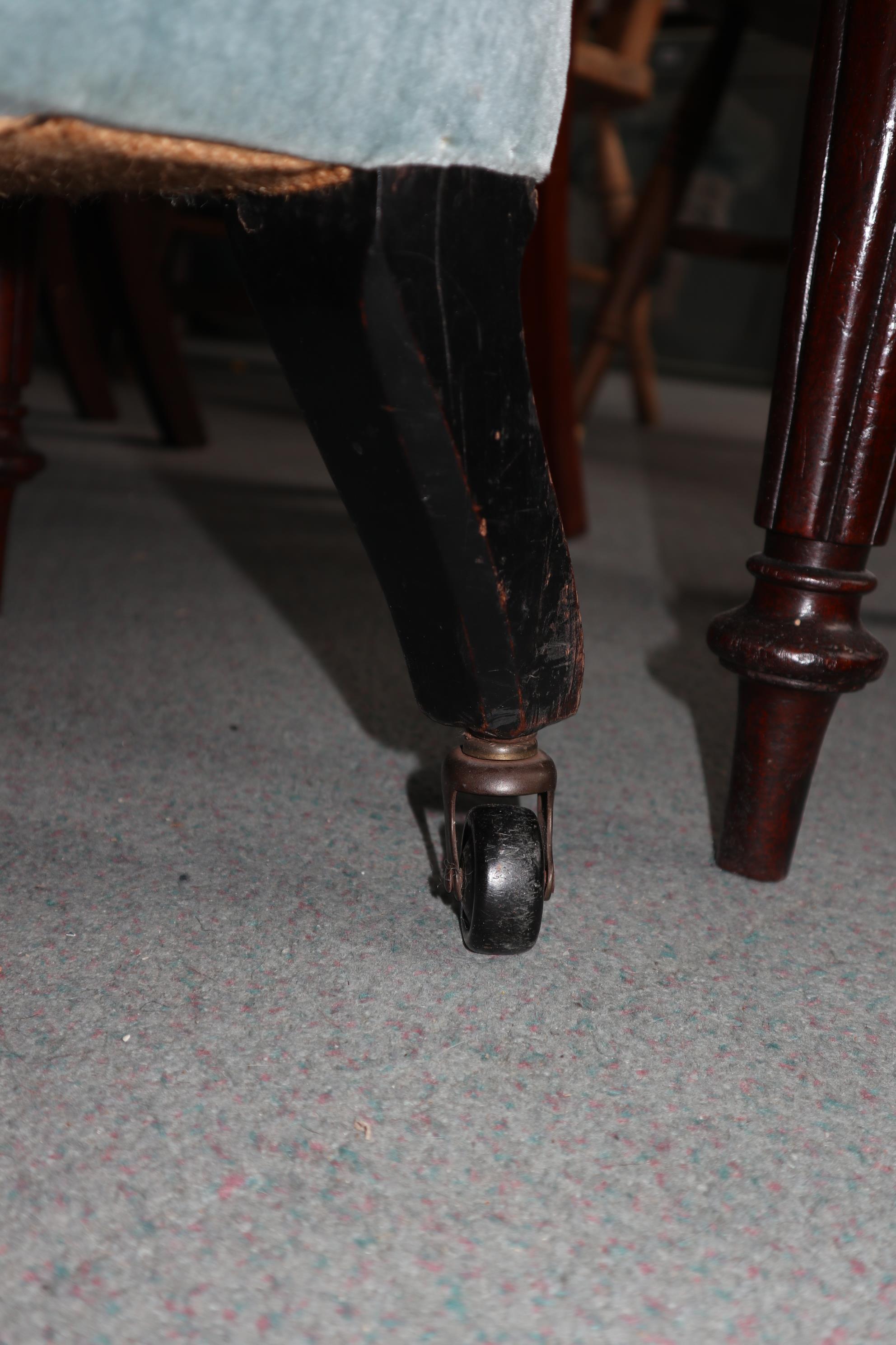 An early 20th century two-seat settee, upholstered in a blue velour, on ebonised turned and castored - Image 4 of 5