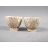 A pair of cream crackle glaze pottery tea bowls, 1 1/2" high