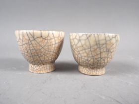 A pair of cream crackle glaze pottery tea bowls, 1 1/2" high