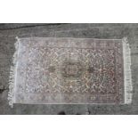 A Turkish silk rug with all-over floral design on a cream and pink ground and multi-borders in