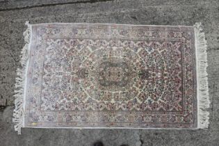 A Turkish silk rug with all-over floral design on a cream and pink ground and multi-borders in