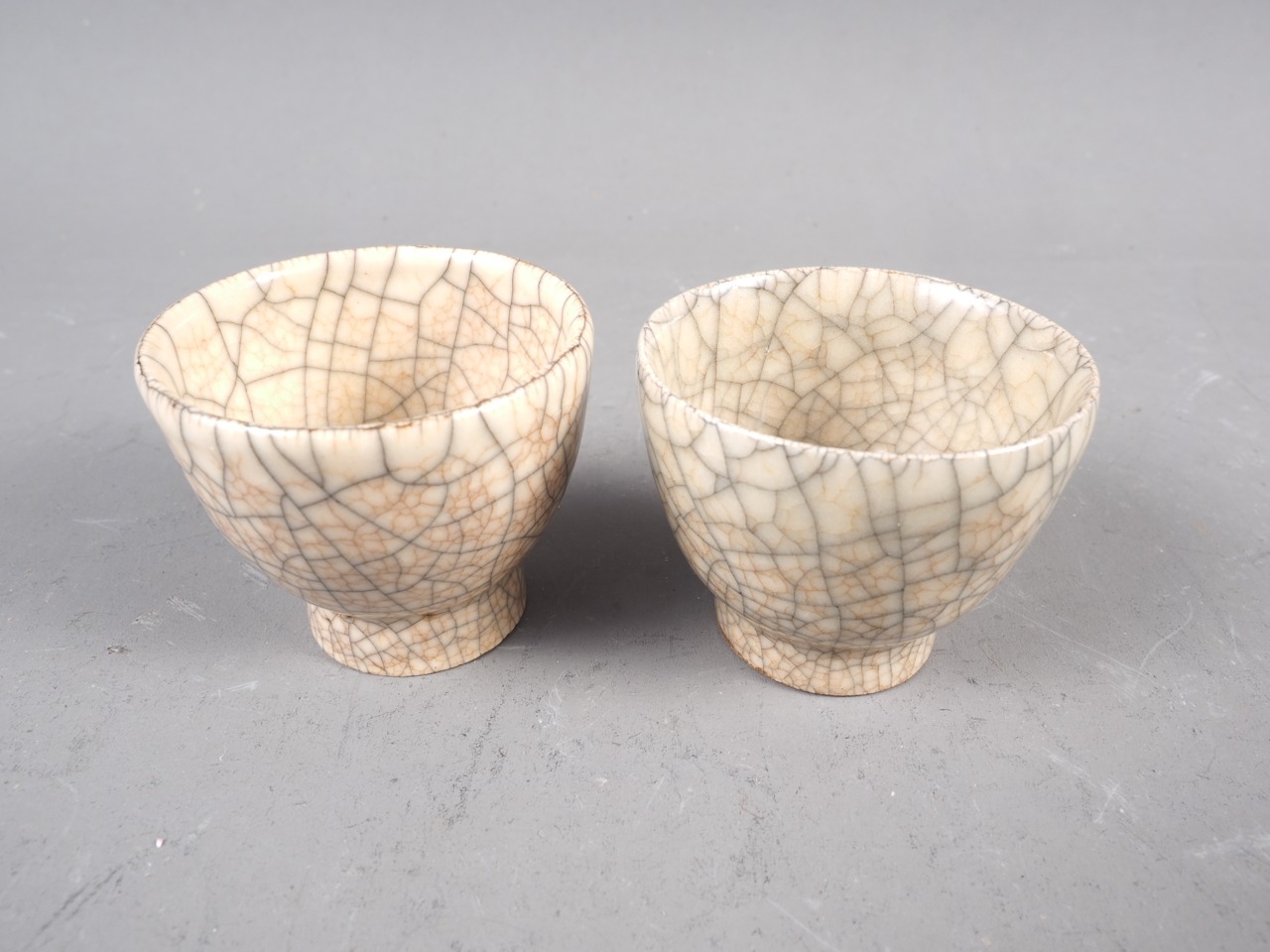 A pair of cream crackle glaze pottery tea bowls, 1 1/2" high - Image 2 of 3