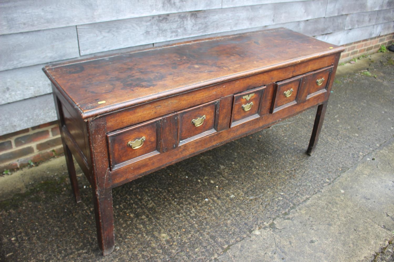 An 18th century fruitwood dresser base, fitted one short and two long fielded panel front drawers,