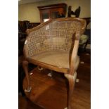 A walnut framed cane seat and back tub-shape elbow chair, on cabriole supports