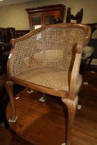 A walnut framed cane seat and back tub-shape elbow chair, on cabriole supports