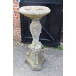 A cast stone bird bath in three sections, on triform base, 20" dia