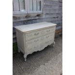 A Louis XVI design grey painted chest of three drawers, on carved shaped cabriole supports, 57" wide