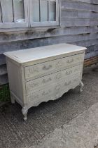 A Louis XVI design grey painted chest of three drawers, on carved shaped cabriole supports, 57" wide