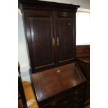 An 18th century oak bureau bookcase, the upper section enclosed panelled doors over fitted writing