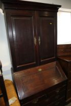 An 18th century oak bureau bookcase, the upper section enclosed panelled doors over fitted writing