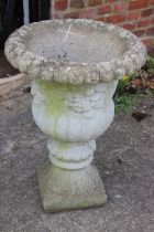 A cast stone campana planter with floral decoration, 19" dia x 26" high