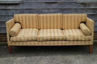 A Howard style Regency design three-seat square arm sofa with loose seat and back cushions, on