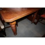 A late Victorian walnut extending dining table with cut corners and extra leaf, on turned