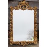 A carved giltwood framed wall mirror of Chippendale design with scroll crest, 42" x 25" overall