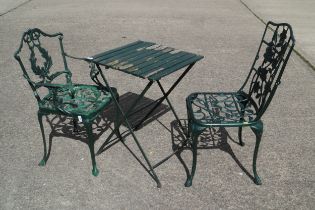 A green painted folding garden table and a pair of cast metal garden chairs