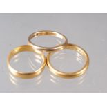 A 22ct gold wedding band, size N, 5.5g, another similar, size L, 4.2g, and a 9ct gold wedding