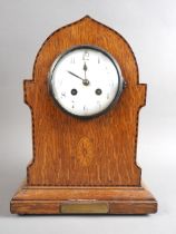 An Edwardian inlaid oak cased mantel clock with white enamel dial and eight-day striking movement,