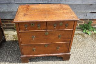 An 18th century oak chest of two short and two long drawers, on bracket feet with later brass