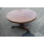 A mid Victorian mahogany circular tilt top dining table, on faceted column, triform base and lion