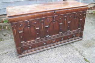 An early 18th century oak mule chest with applied mouldings and arcaded front over one long drawer