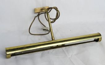 A brass wall mounted picture downlighter lamp.