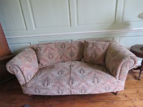 A two seater cloth covered oversprung scroll arm settee, 6ft wide, complete with loose cushions.